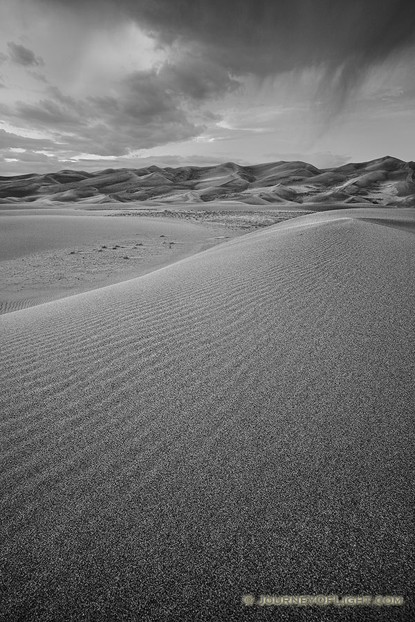 Clouds from a storm rolling through the Great Sand Dunes almost touch the top of the dunes. - Great Sand Dunes National Park Photography
