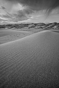 Clouds from a storm rolling through the Great Sand Dunes almost touch the top of the dunes. - Colorado Black and White Landscape Photograph