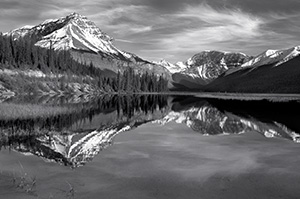 Only a small ripples disturbs the reflection of the mountains in the distance. - 777 Photograph