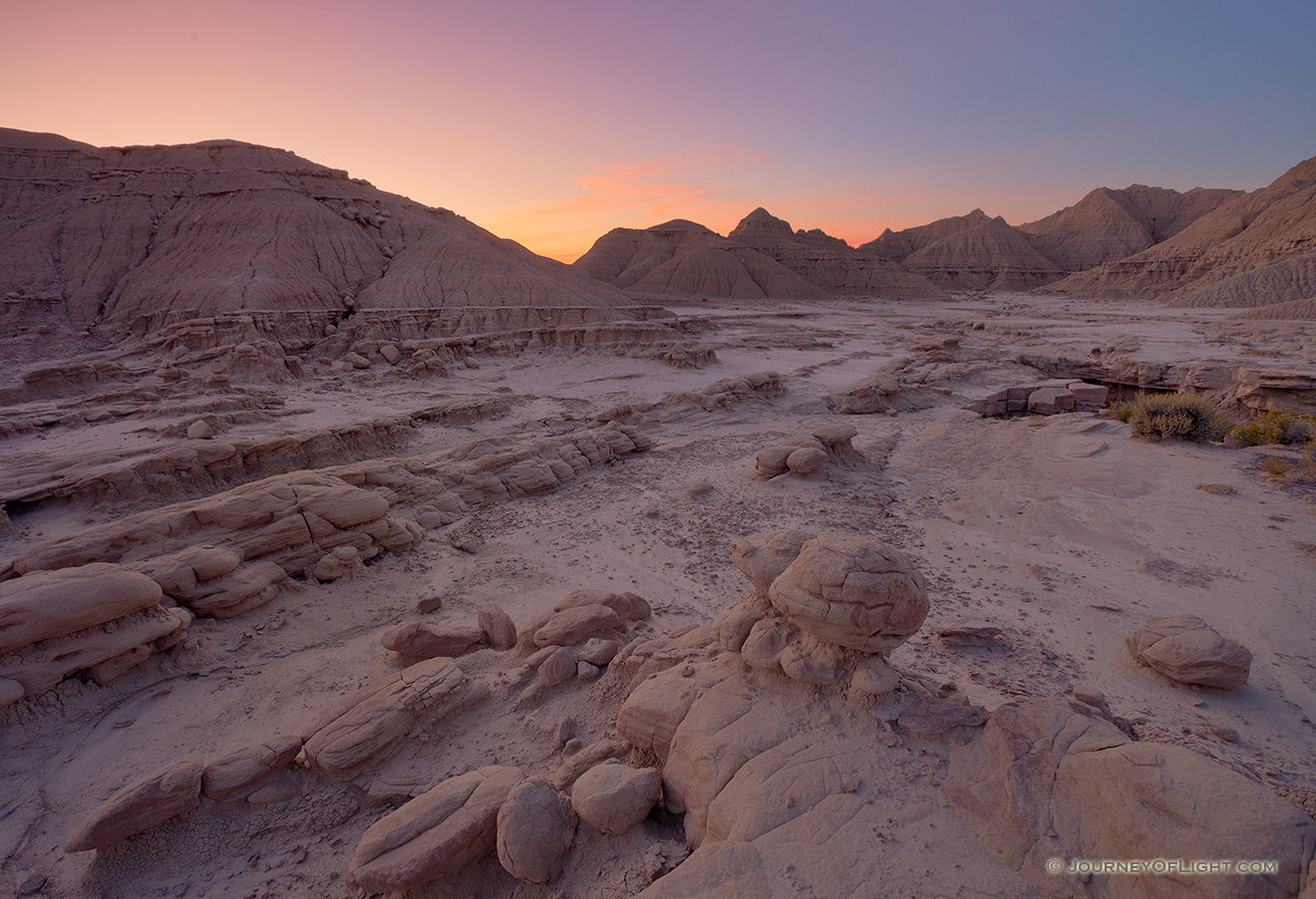 The warm glow of the sunrise radiants from the east bathing the otherworldly Toadstool Geologic Park in etheral warm hues. - Toadstool Geologic Park Picture