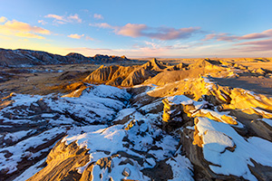 Scenic landscape photograph of sunset at Toadstool Geologic Park in western Nebraska after snow. - Nebraska Photograph