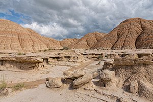 Afternoon clouds hover over the otherwordly landscape at Toadstool Geologic Park in Northwestern Nebraska. - Nebraska Photograph