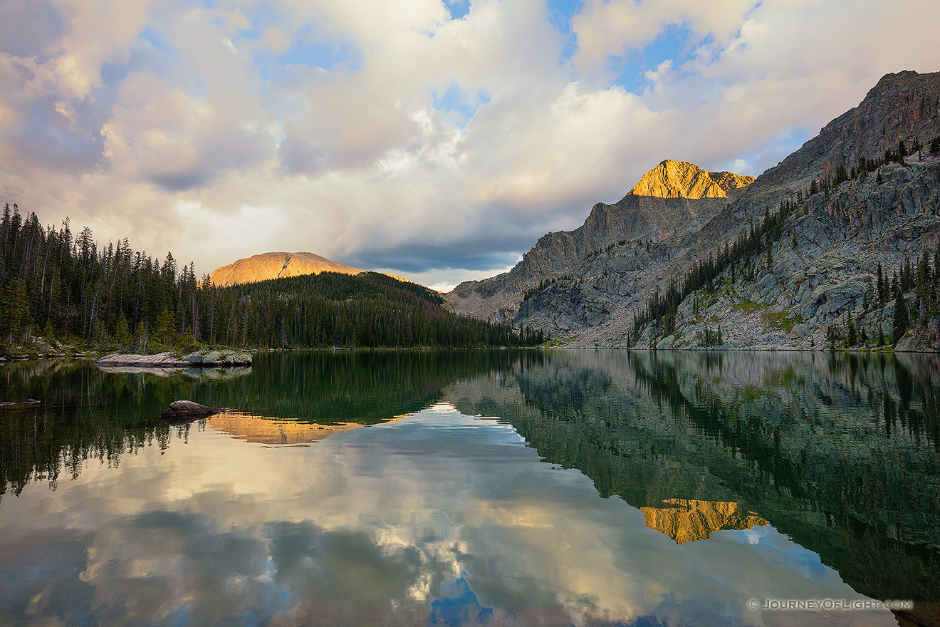 Mountains glow with the last light of a cool autumn day while an almost perfect reflection shimmers in Nanita Lake.