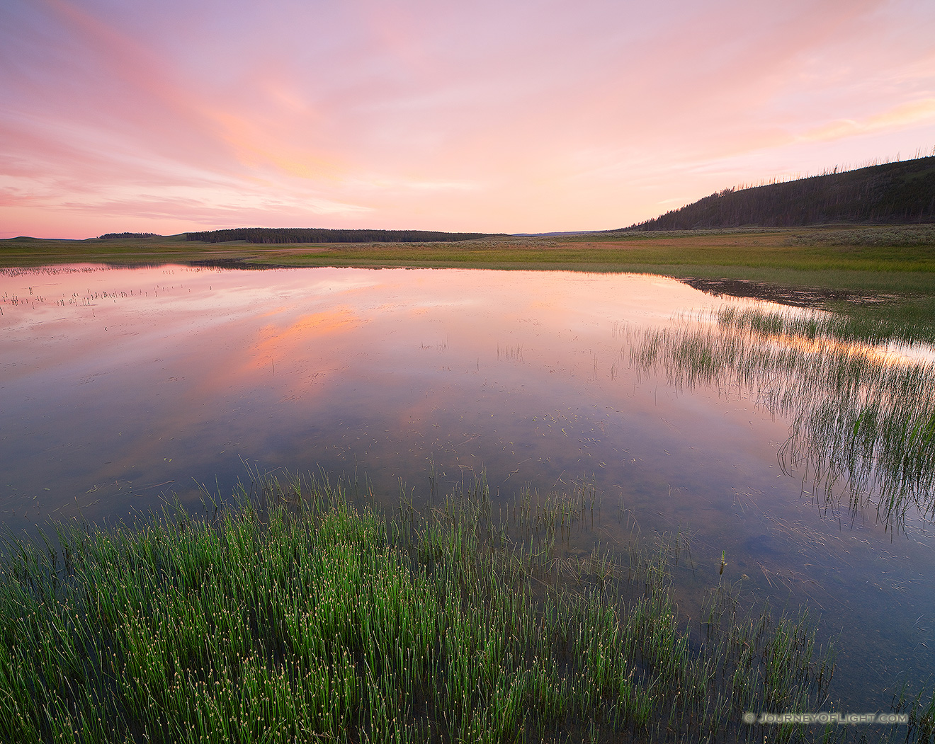 Clouds are illuminated with bright reds and oranges during a vivid sunset in the Hayden Valley of Yellowstone National Park in Wyoming. - Yellowstone National Park Picture