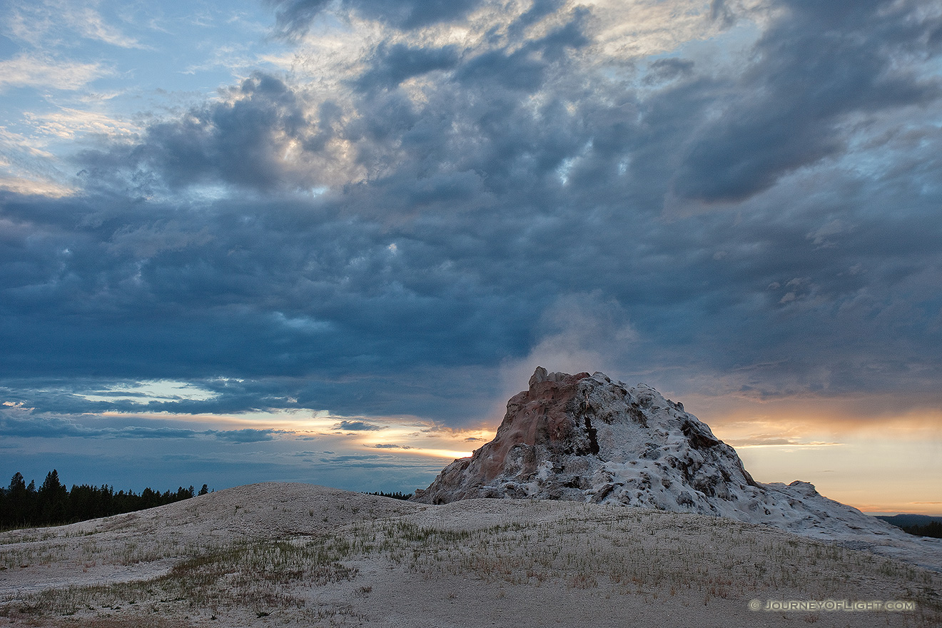 Castle Geyser steams as a storm front approaches in the late evening at Yellowstone National Park in Wyoming. - Yellowstone National Park Picture