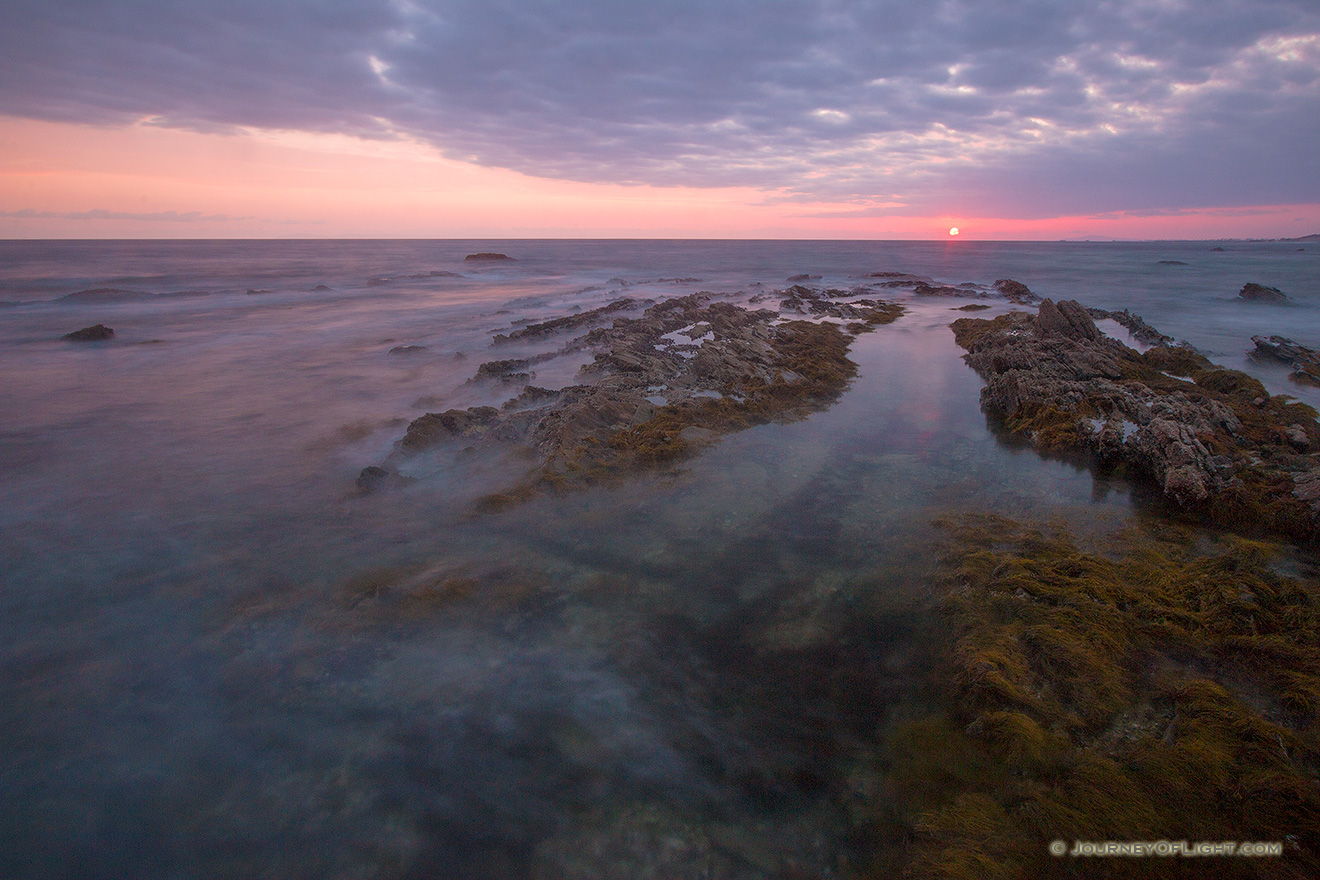 An orange sun sets over the Pacific Ocean at Crystal Cove State Park, California. - State of California Picture