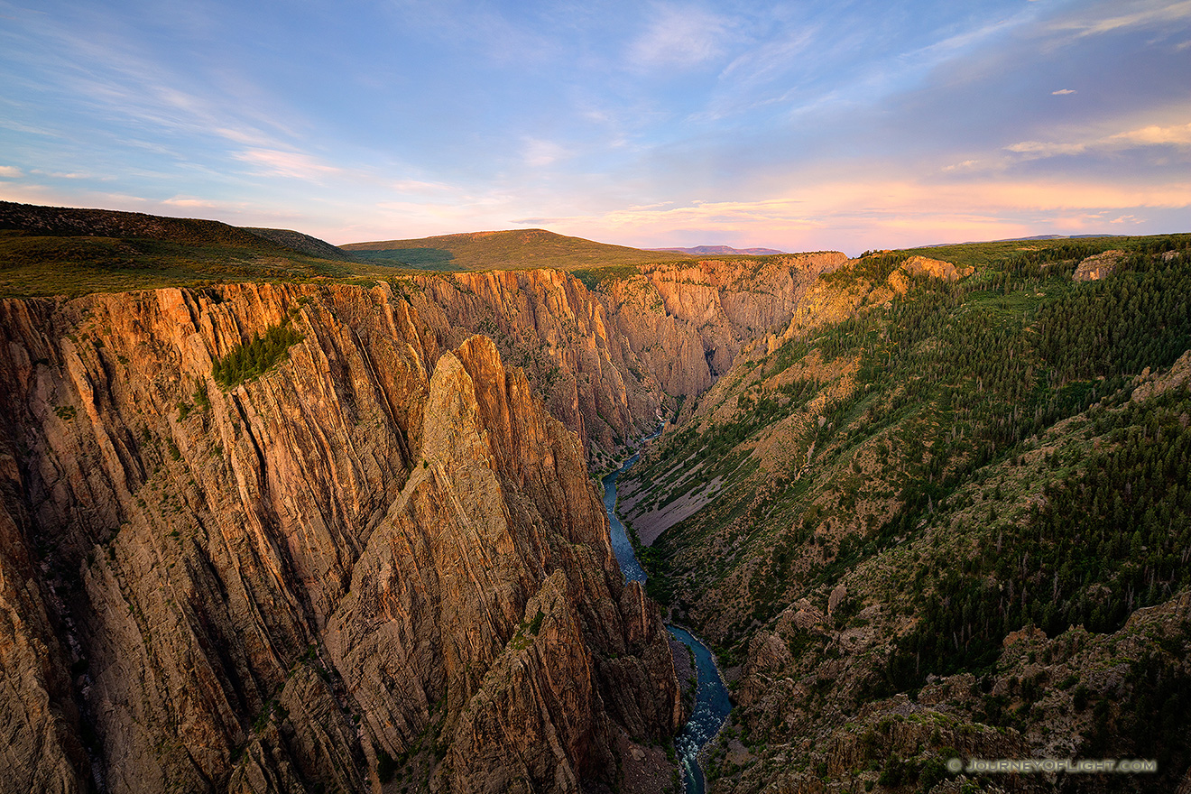 As the sun sets in the west in Black Canyon of the Gunnison National Park, the last glow of the day skims the canyon walls to the east. - Colorado Picture