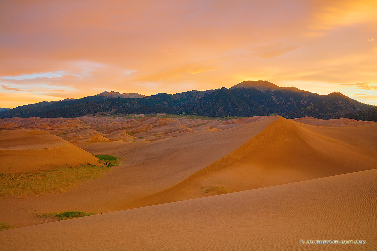 Red sunset over a sea of ripely sand at Colorado's Great Sand Dunes  National Park, home to the tallest sand d…