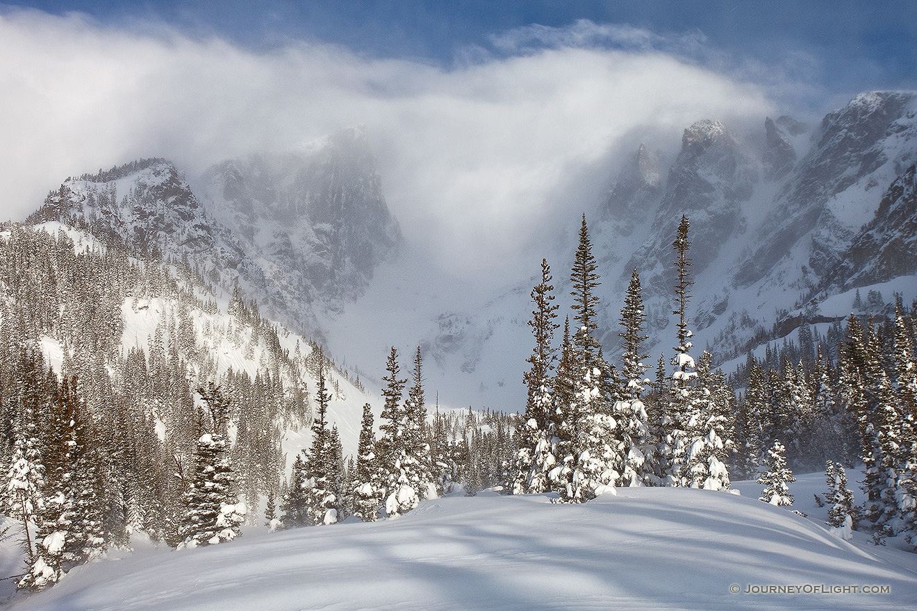 Hallet and Flattop are partially hidden by the blowing snow and clouds due to a large mid-May snowfall. - Rocky Mountain NP Picture