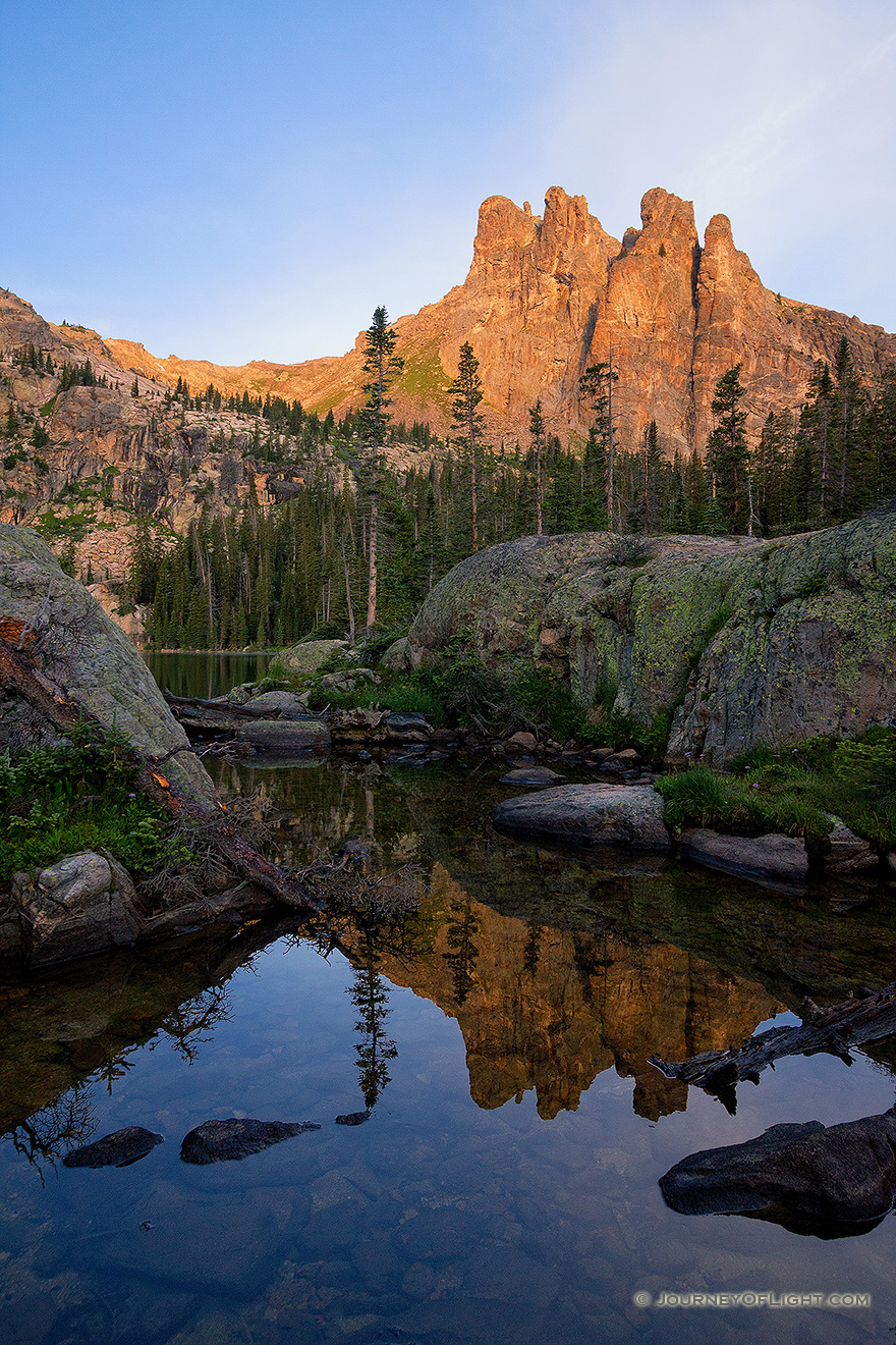 The summer sun shines a warm glow on Ptarmigan Mountain it's reflection in an outlet of Lake Nanita below. - Colorado Picture