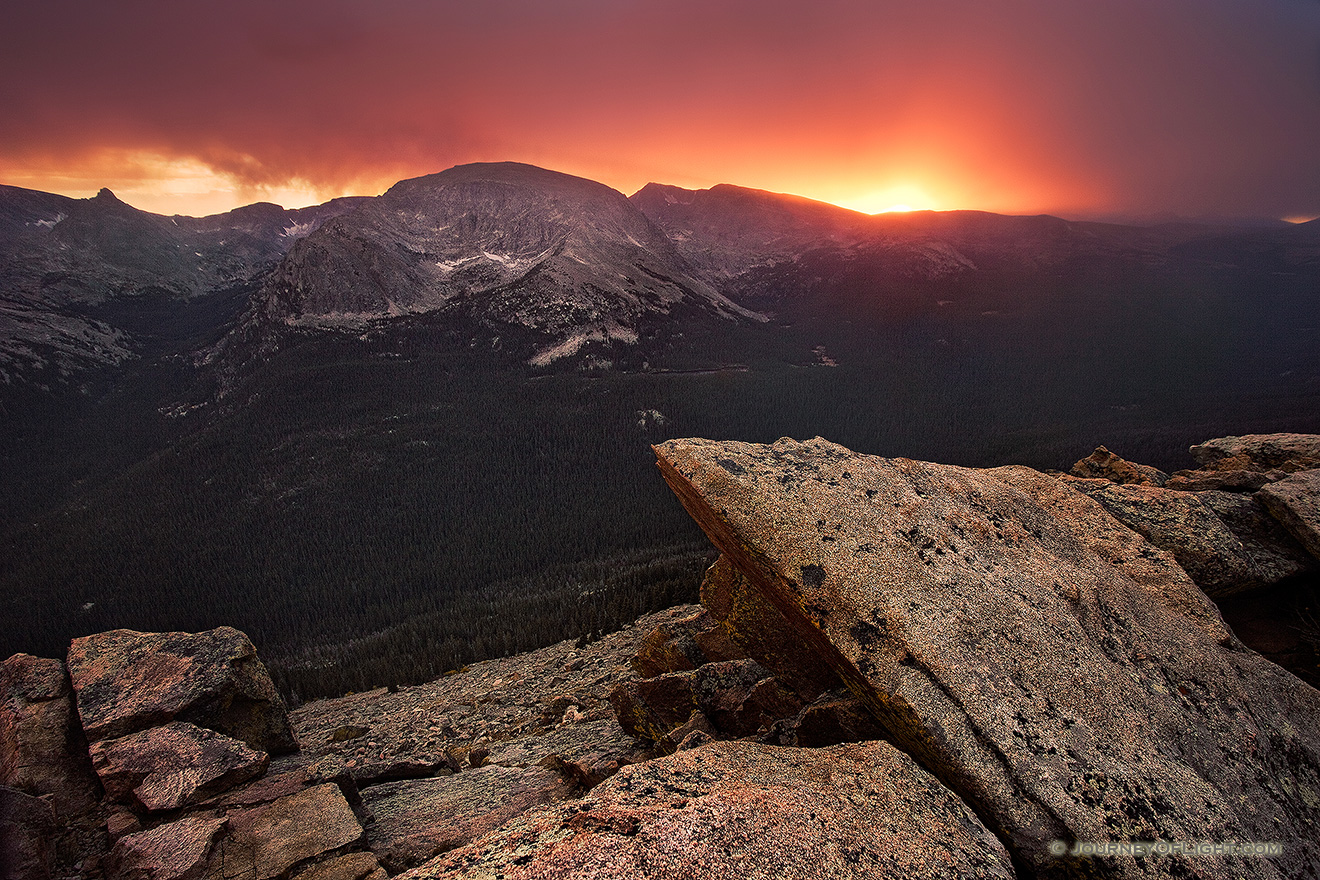 The sun shines brightly for one last minute before setting illuminating the clouds during a snowstorm at the Forest Canyon Overlook at Rocky Mountain National Park. - Rocky Mountain NP Picture