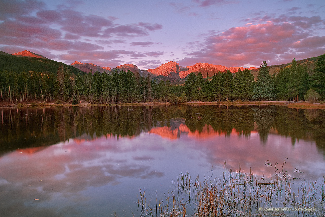During a cool October sunrise the peaks of the continental divide, Powell Peak, Taylor Peak, Otis Peak, Hallett Peak, and Flattop Mountain are reflected in the calm waters of Sprague lake. - Rocky Mountain NP Photography