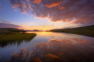 Glowing with intensity, clouds drift above a tarn near Independence Pass in the White River National Forest in Colorado. - Colorado Landscape Photograph