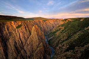 As the sun sets in the west in Black Canyon of the Gunnison National Park, the last glow of the day skims the canyon walls to the east. - Colorado Landscape Photograph
