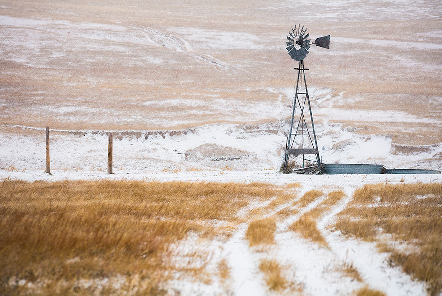 Scenic landscape panoramic photograph of a windmill and a road in the winter at Oglala National Grasslands. - Nebraska Photography