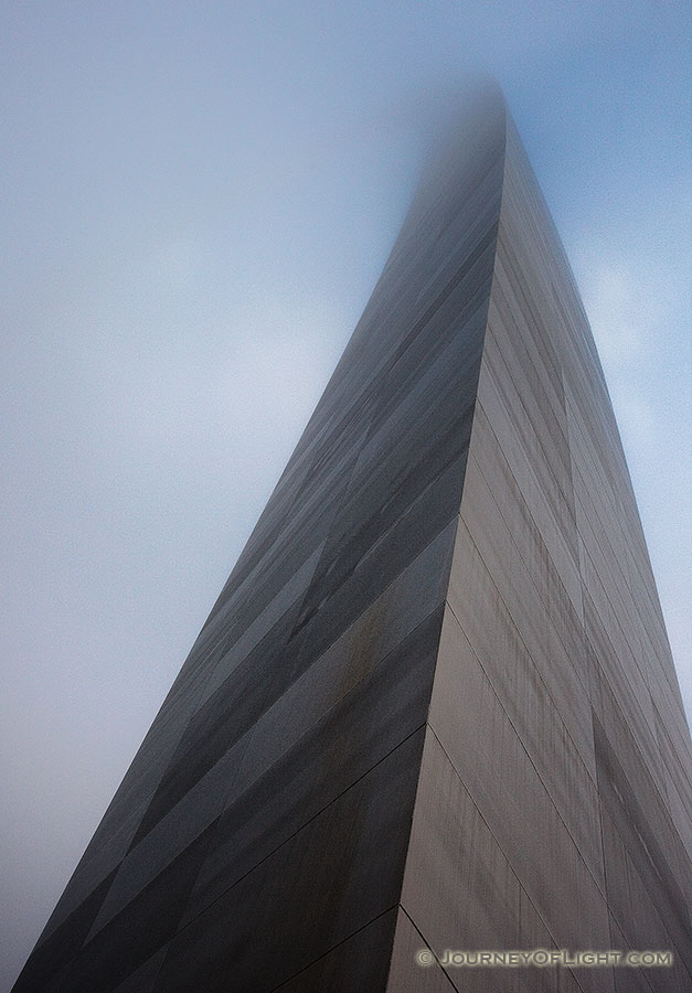 The Gateway Arch curves through the sky and into the fog.  - Jefferson National Expansion Memorial Photography