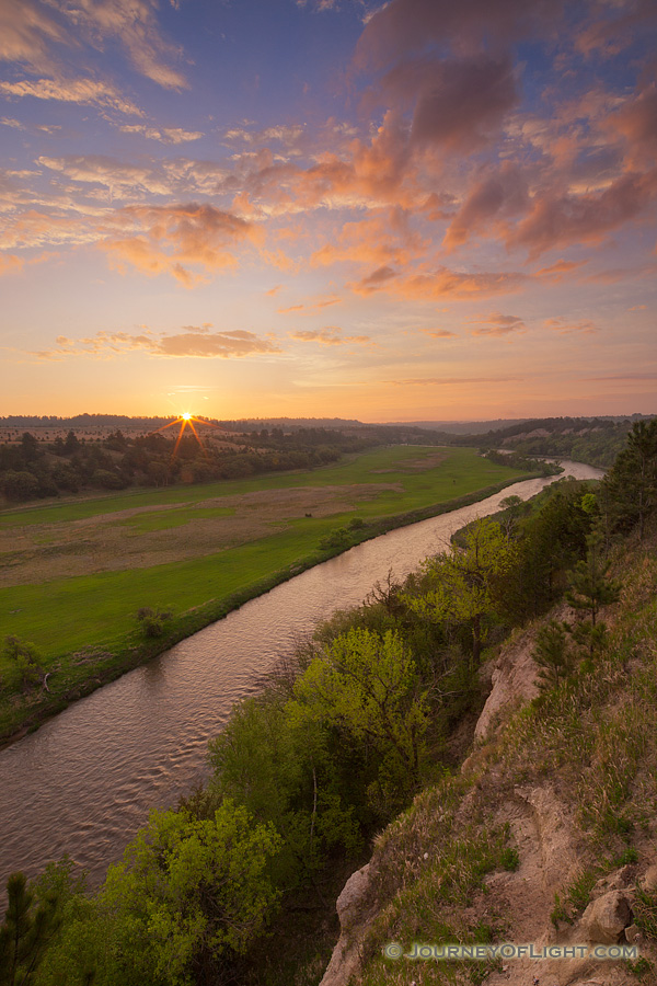 The Niobrara is one of the most popular rivers for canoeing and tubing in the United States.  On a beautiful spring sunrise, the river lazily meanders into the east as the sun rises in the distance. - Valentine Photography