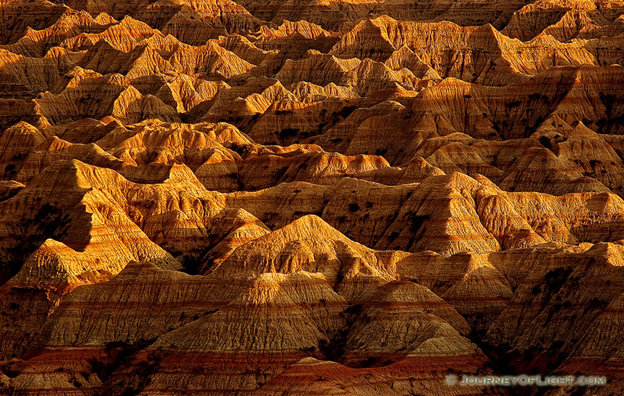 The late afternoon sun creates abstract shapes from the long shadows in the Badlands, South Dakota. - Badlands NP Photography