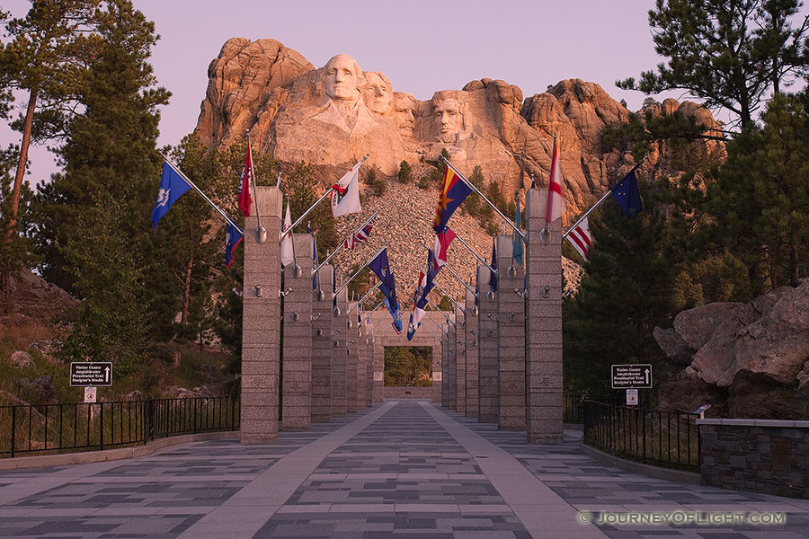 Mt. Rushmore National Monument at sunrise with the Avenue of Flags in the Black Hills of South Dakota. - Mt. Rushmore NM Photography