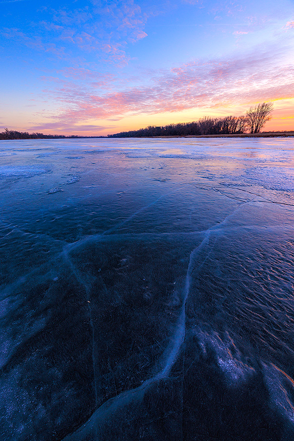 A scenic landscape photograph of the sunset over the frozen lake at DeSoto NWR, Nebraska. - Nebraska Photography