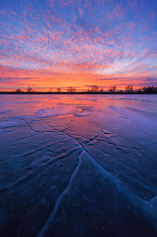 A scenic landscape photograph of a sunset and a frozen lake at DeSoto NWR, Nebraska. - Nebraska Photography
