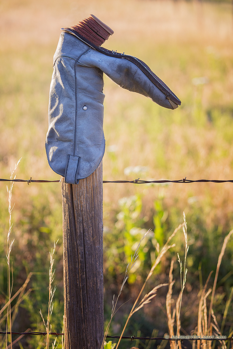 A common scene in western Nebraska, an old cowboy boot adorns a wooden fence at Ash Hollow State Park. - Sandhills Picture