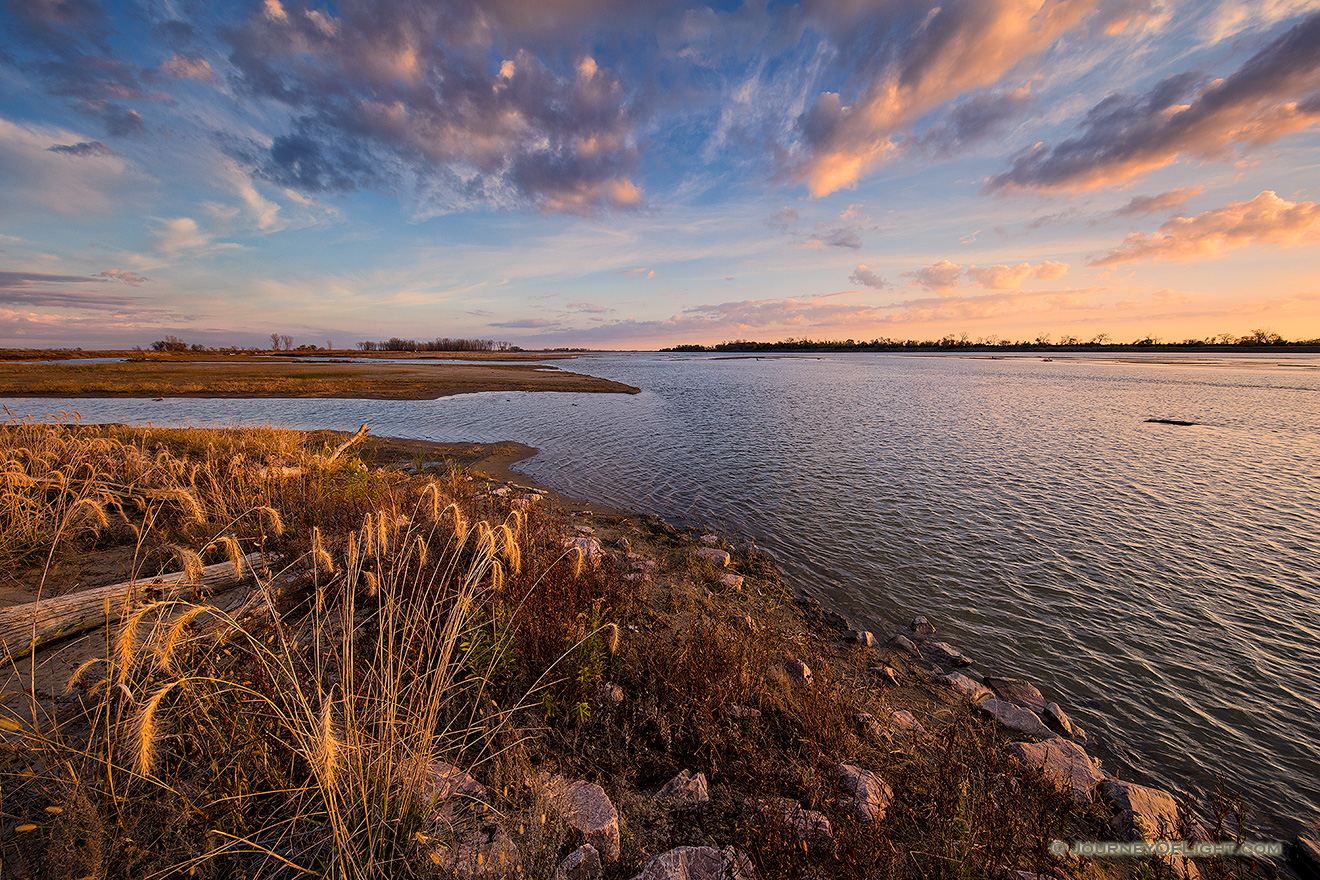 Bright puffy clouds float across the sky as the morning sun rises over the Missouri at Ponca State Park in northeastern Nebraska. - Ponca SP Picture