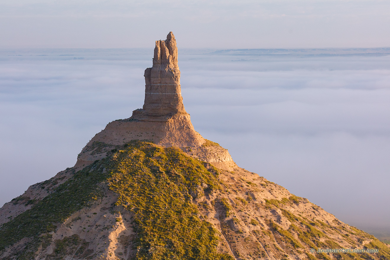 A scenic landscape photograph of Chimney Rock National Historic Site in fog. - Nebraska Picture