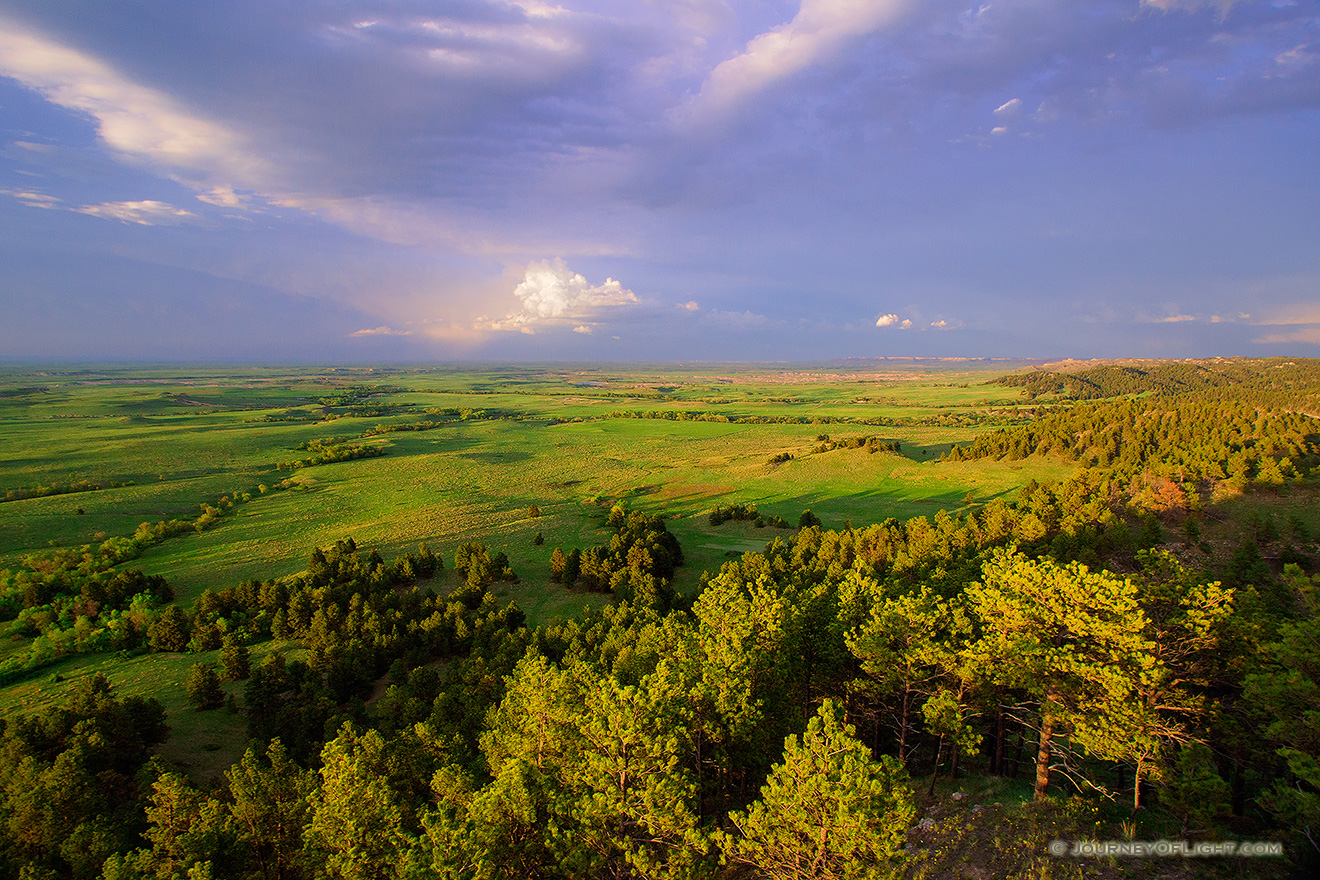 In the extreme Northwestern edge of Nebraska from high on the pine ridge escarpment the afternoon sun warms the rain drenched plains below. - Nebraska Picture