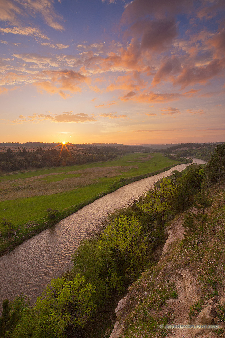 The Niobrara is one of the most popular rivers for canoeing and tubing in the United States.  On a beautiful spring sunrise, the river lazily meanders into the east as the sun rises in the distance. - Valentine Picture