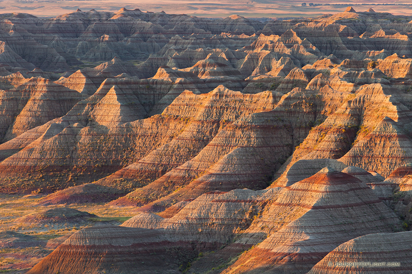 The warm light of the recently risen sun illuminates the Badlands of South Dakota in Badlands National Park. - South Dakota Picture