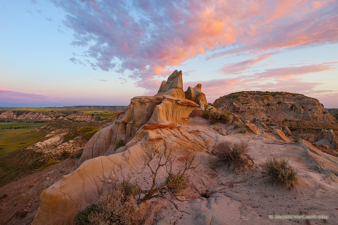 The warm glow of the rising sun illuminates badlands in western North Dakota in Theodore Roosevelt National Park. - North Dakota Picture