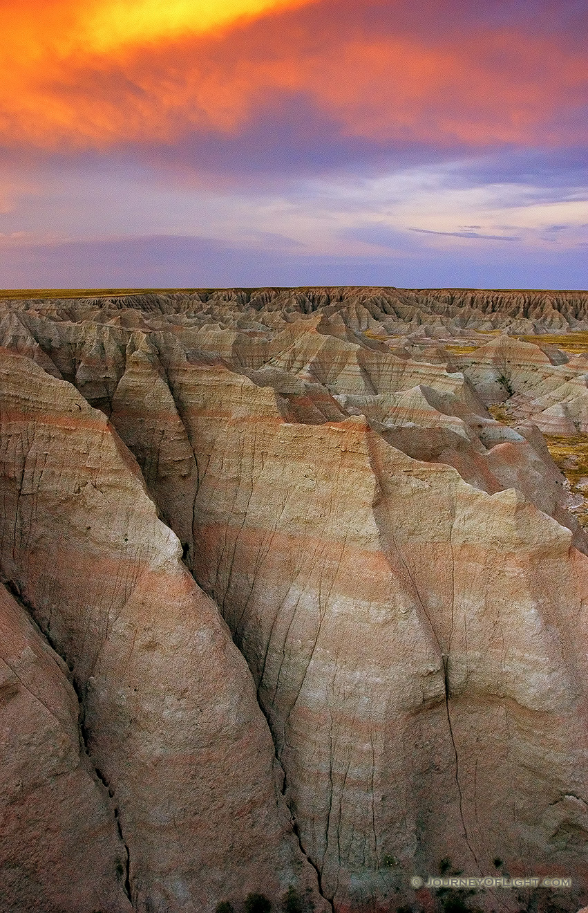 Fiery reds and oranges dominate the sunset over the Badlands National Park in South Dakota. - Badlands NP Picture