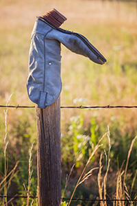 A common scene in western Nebraska, an old cowboy boot adorns a wooden fence at Ash Hollow State Park. - Nebraska Photograph