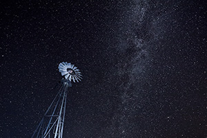 A Nebraska landscape scenic photograph of a windmill under a night sky with lots of stars. - Nebraska Photograph