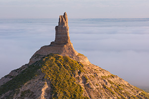 A scenic landscape photograph of Chimney Rock National Historic Site in fog. - Nebraska Photograph