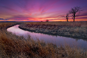 A small chute flows toward an early spring sunset through a tract of native prairie grasses at Boyer Chute National Wildlife Refuge near Ft. Calhoun. - Nebraska Photograph