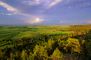 In the extreme Northwestern edge of Nebraska from high on the pine ridge escarpment the afternoon sun warms the rain drenched plains below. - Nebraska Landscape Photograph