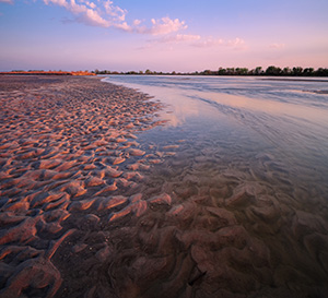 On a sandbar near Two Rivers State Recreation Area, the Platte River flows into the distance as the sun sets to the west. - Nebraska Photograph