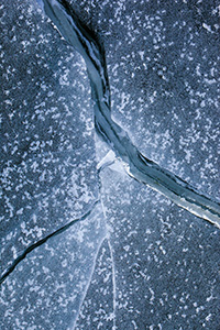 Deep cracks form in the ice from frigid cold weather on Lake Wehrspann at Chalco Hills, Nebraska. - Nebraska Photograph