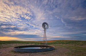 Dusk falls as clouds hover over a remote windmill in McKelvie National Forest in western Nebraska. - Nebraska Photograph