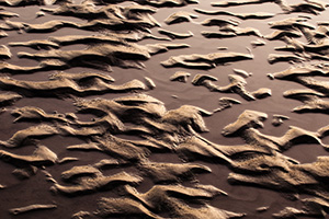 Capturing a photograph of a nature abstract, sand and water collide and intermingle to create interesting patterns along the banks of the Platte River in Eastern Nebraska. - Nebraska Photograph