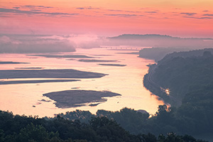 Morning fog hangs low across the Platte River and a train chugs down the tracks as seen from the tower at Platte River State Park. - Nebraska Photograph