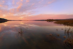 On a calm and quiet evening in early November at Niobrara State Park, just prior to sunset, I hiked down to near the confluence of the Missouri River and Niobrara Rivers and took in the scene.  The last of the light of the sun illuminated the clouds and the still Missouri reflected the scene sandwiched between the hills of Nebraska and South Dakota. - Nebraska Photograph