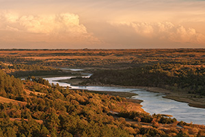 Storm clouds hover over the snaking Niobrara River near sunset in Keha Paha County in north central Nebraska. - Nebraska Photograph