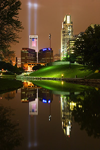 On September 11, 2006 Omaha, Nebraska paid tribute to the victims of 9/11 by hanging 2 large United States flags on the Woodmen tower and by shining two large lights into the sky. - Nebraska Photograph