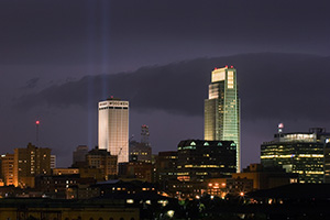 On September 11, 2006 Omaha, Nebraska paid tribute to the victims of 9/11 by hanging 2 large United States flags on the Woodmen tower and by shining two large lights into the sky.  This particular photo was taken during a spectacular fall lightning storm. - Nebraska Photograph