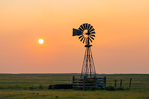 Scenic landscape photograph of a windmill and sun at Oglala National Grasslands. - Nebraska Photograph
