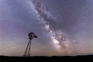 A scenic landscape photograph of a windmill and the Milky Way in the sandhills of Nebraska. - Nebraska Photograph