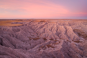 On a warm autumn evening from high on the plains, the last light of the day gives the canyons of the Oglala National Grassland just off the Hudson-Meng trail in western Nebraska a warm glow. - Nebraska Photograph